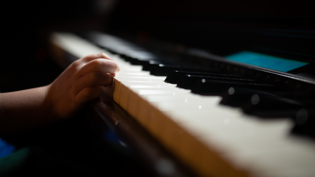 Closeup of child hand on piano keys